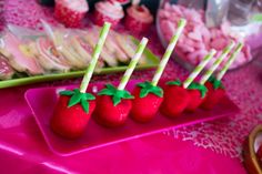 strawberries are arranged on sticks in the shape of strawberrys with green leaves and sprinkles