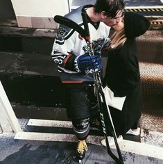 a man and woman kissing while standing next to each other with skis on their feet