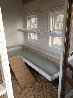 the inside of a chicken coop with stairs and windows