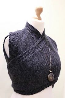 a mannequin wearing a gray sweater with a necklace on it's neck