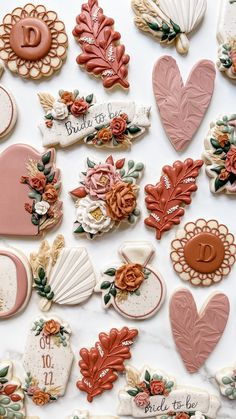 many decorated cookies are displayed on a white surface with flowers and hearts in the middle