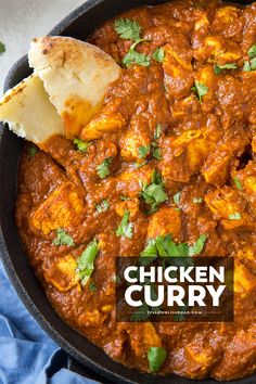 chicken curry in a skillet with bread and cilantro