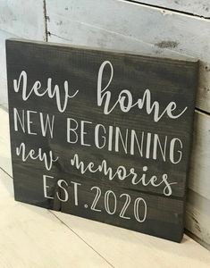 a wooden sign that says new home, new beginning and memories