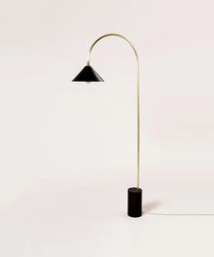 a black and gold floor lamp on a white background with the light turned off to show its dim lighting