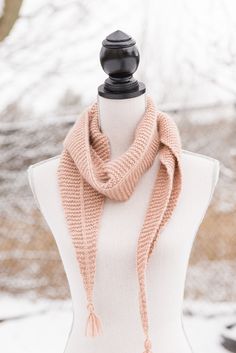 a white mannequin with a pink scarf on it