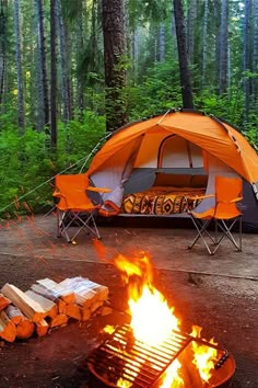 an orange tent sitting in the middle of a forest next to a campfire with logs