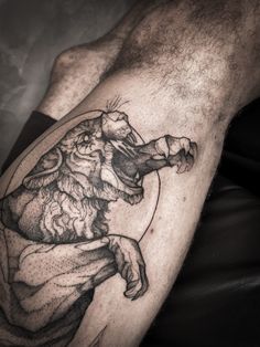 a black and white photo of a man's leg with a lion tattoo on it