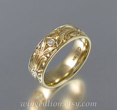 a wedding ring with an intricate design on the side and diamond set in the center