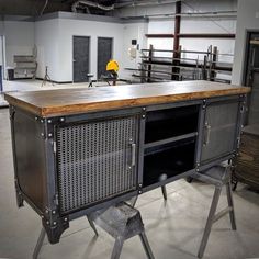 an industrial kitchen island made out of metal and wood with perfored panels on the top