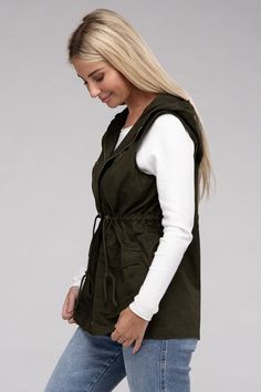 A versatile fashion piece that seamlessly blends style and utility. This vest boasts a convenient zipper and snap-button closure, ensuring ease of wear, while the adjustable drawstring waist provides a personalized, flattering fit. With practical pockets, it's a fashionable yet functional addition to any outfit, making it perfect for both casual and statement looks. Model is wearing a SmallModel SpecsHeight: 5'8"Bust: 34D Waist: 24"Hips: 37"*Color may vary slightly due to monitor resolutionMade Fall Streetwear Vest With Side Pockets, Hooded Vest With Pockets For Fall, Urban Vest With Pockets For Fall, Drawstring Outerwear For Fall Outdoor Activities, Urban Style Vest With Pockets For Fall, Trendy Hooded Vest For Spring, Urban Fall Vest With Pockets, Fall Outerwear With Drawstring For Outdoor Activities, Trendy Hooded Spring Vest