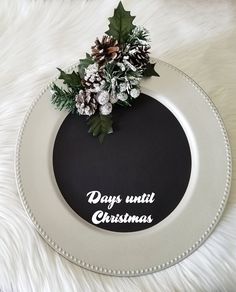 a white plate topped with holly and pine cones on top of a fur covered table