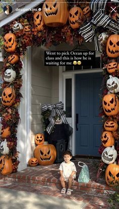 a little boy sitting in front of a house decorated for halloween