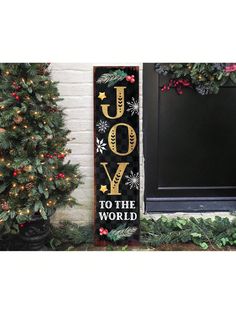 a wooden sign that says joy to the world next to a christmas tree and wreath