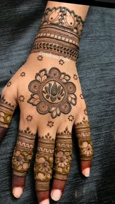 a woman's hand with henna tattoos on it