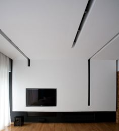 an empty room with a flat screen tv on the wall