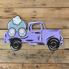 a purple toy truck with an elephant on the front and back wheels is sitting on a wooden surface