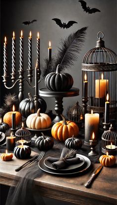 a table topped with candles and pumpkins next to a birdcage filled with feathers