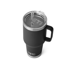 the yeti travel mug is shown with its lid open and it has a straw in it