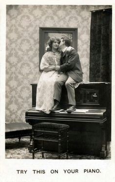 an old photo of a man and woman sitting on top of a piano