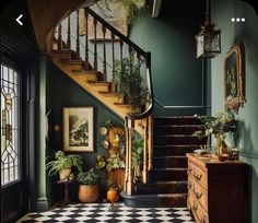 a staircase with potted plants next to it and a checkered rug on the floor