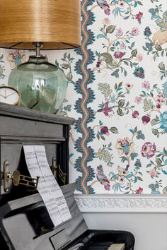 an old piano sitting in front of a wall paper