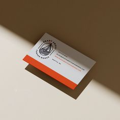 an orange and white business card sitting on top of a table