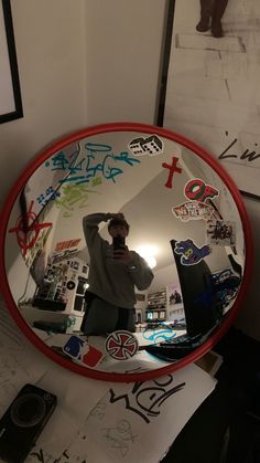 a man taking a selfie in a mirror with stickers all over the frame