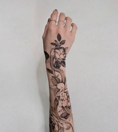 a woman's arm with a tattoo on it and flowers in the middle of her arm