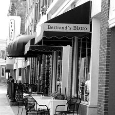 black and white photograph of restaurant tables on the sidewalk