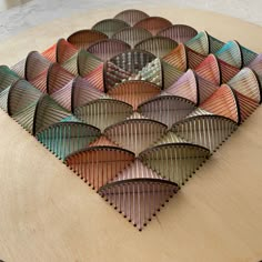 a wooden table topped with lots of different colored paper plates on top of each other