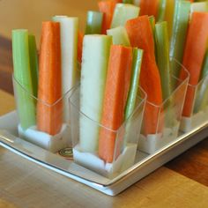 several small trays filled with veggies on top of a wooden table