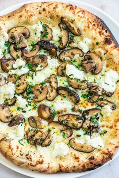 a pizza topped with mushrooms and cheese on a white plate