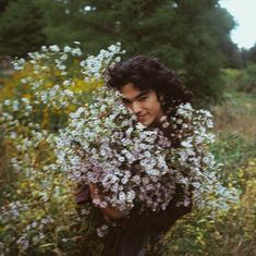 a young man holding flowers in his hands