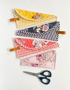 four pieces of fabric are laid out on top of each other with scissors next to them