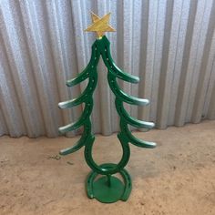 a green metal christmas tree with a star on top