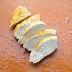 slices of chicken sitting on top of a pan covered in gravy and seasoning