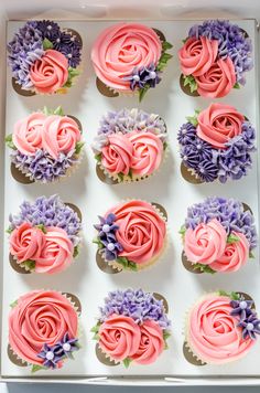 a box filled with cupcakes covered in pink and purple frosting