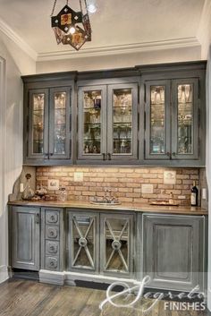 an old fashioned kitchen with grey cabinets and wood flooring is featured in this image