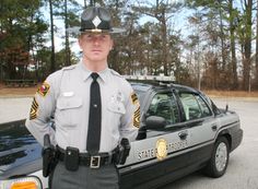 a police officer standing next to his patrol car