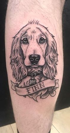 a black and white photo of a cocker spaniel tattoo on the leg