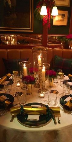 the table is set with place settings and candles