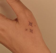 a person's hand with three small stars on it