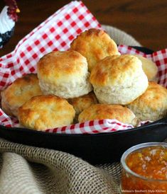 some biscuits are in a black pan on a red and white checkered cloth