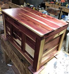 a large wooden box sitting on top of a table in a room filled with tools