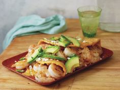 a plate with shrimp, avocado and rice on it next to a drink