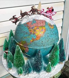 a globe with christmas trees and santa clause on top