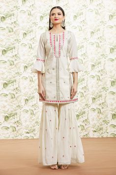 White cotton kurta with floral, stripe pattern, sequin, applique, gota embroidery and contrast border details. Paired with gharara with butti pattern, contrast resham work and dupatta with gota embroidered border.
Components: 3
Pattern: Embroidered
Type Of Work: Resham, Sequin, Gota and Mirror Work
Neckline: Keyhole Round Neck
Sleeve Type: Bell Sleeves
Fabric: Cotton, Dupatta: Organza, Lining: Cotton
Color: White
Other Details: 
Cut work hem details
Contrast pink details
Side slits on kurta
Atta Designer Sharara With Cutdana For Spring, Designer Cutdana Sharara For Spring, Traditional Spring Sharara With Dori Work, White Semi-stitched Sharara For Spring, Traditional Spring Sharara With Cutdana, Traditional Sharara With Drape For Spring, Traditional Cutdana Sharara For Spring, Spring Festive Sharara With Gota Work, White Bohemian Sharara For Spring