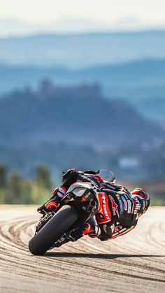 a man riding a motorcycle on top of a dirt road