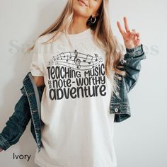 Teaching Music Is A Note Worthy Adventure | Music Teacher Shirt | Teach Tshirt | Gift For Teacher | Retro Teacher T-Shirt | New Teacher Gift **Note: FOR A RELAXED FIT, CHOOSE YOUR GO-TO SIZE. TO ACHIEVE AN OVERSIZED, LOOSE FIT, WE RECOMMEND GOING UP AT LEAST 1-2 SIZES. MODELS IN PHOTOS ARE WEARING 1-2 SIZES LARGER THAN THEIR GO-TO SIZE. ABOUT THIS AWESOME COMFORT COLORS T-SHIRT ... -These are Comfort Colors unisex garment-dyed t-shirts, made with 100% ring-spun cotton. They have UNISEX sizing - Music-themed White Tops With Letter Print, Music-themed Cotton Crew Neck Top, Music-themed Cotton Tops With Crew Neck, Music-themed Cotton Tops With Slogan, Music-themed Cotton Slogan Tops, Music-themed Cotton Tops With Graphic Print, Music-themed Cotton Top With Graphic Print, Music-themed Cotton Graphic Top, Music-themed Slogan Crew Neck Top