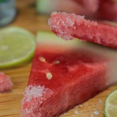 slices of watermelon and limes on a cutting board with sugar sprinkled on them